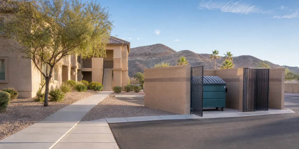 Clean apartment dumpster enclosure in a desert Southwest community for Bin Butler door-to-bin service